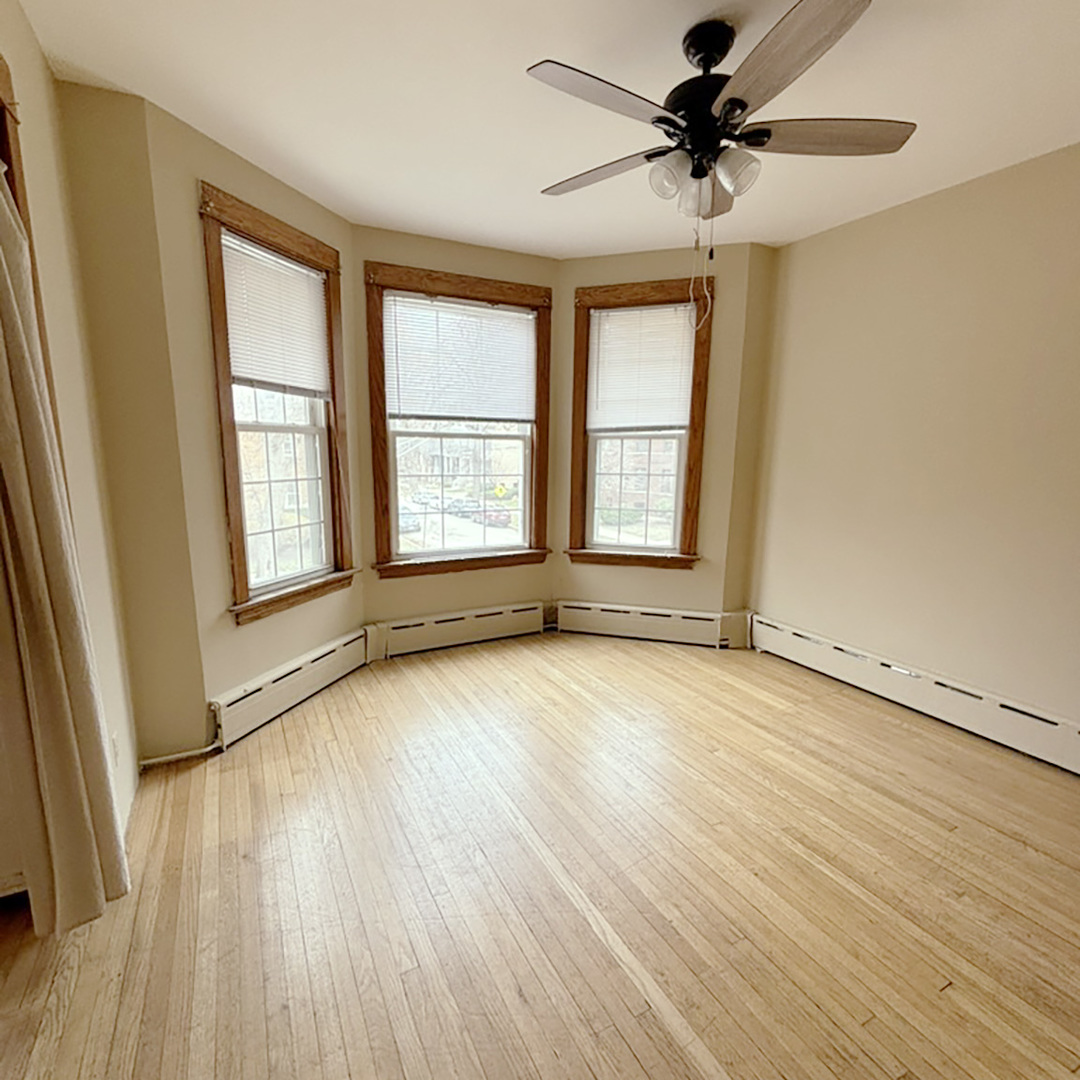 2133 West Grace Street, Unit 2 Chicago, IL 60618 - Photo 5 of 22 an empty room with wooden floor and windows