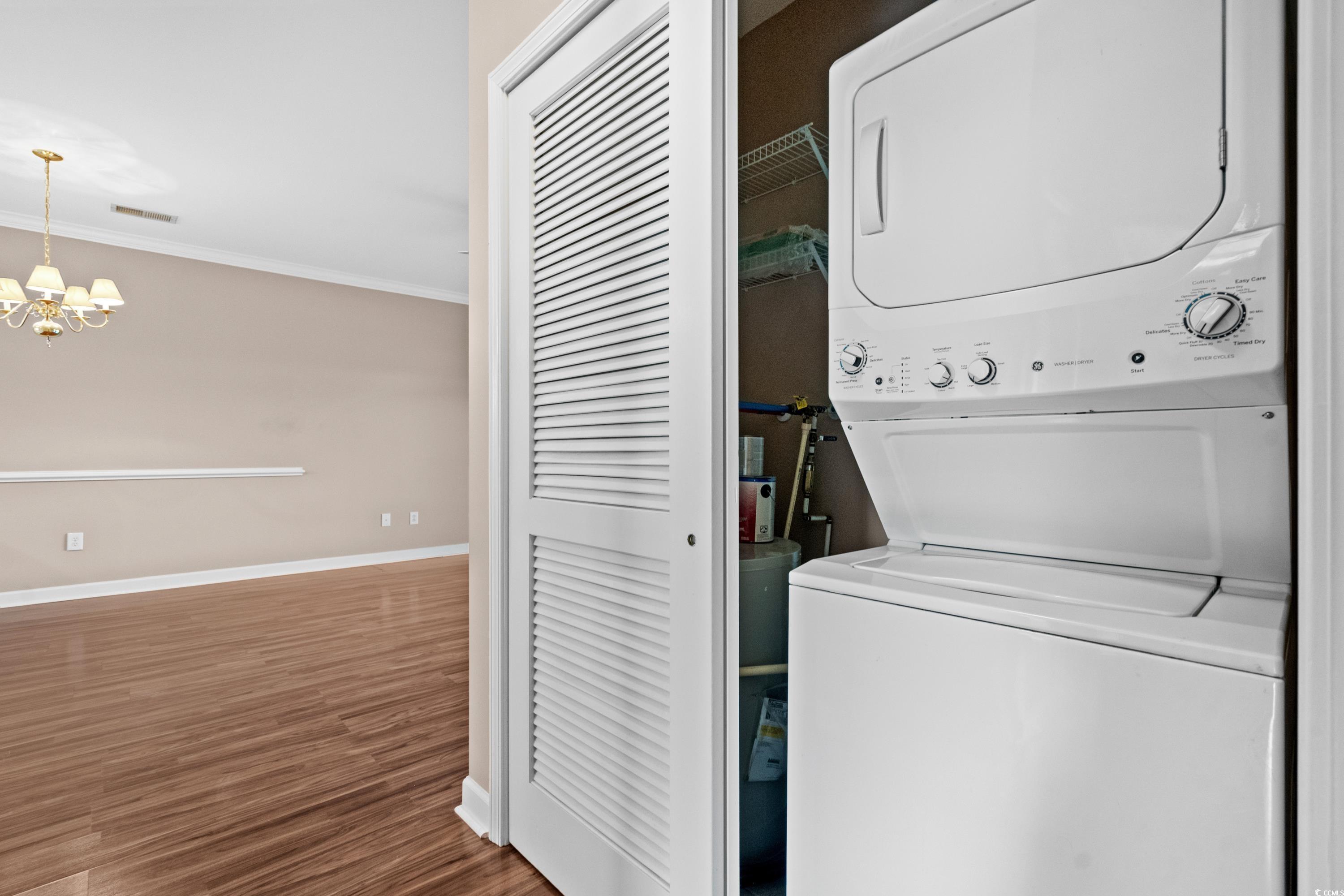 336 Kiskadee Loop, Unit B Conway, SC 29526 - Photo 31 of 40 Laundry area with ornamental molding, hardwood / wood-style floors, stacked washer / dryer, and an inviting chandelier