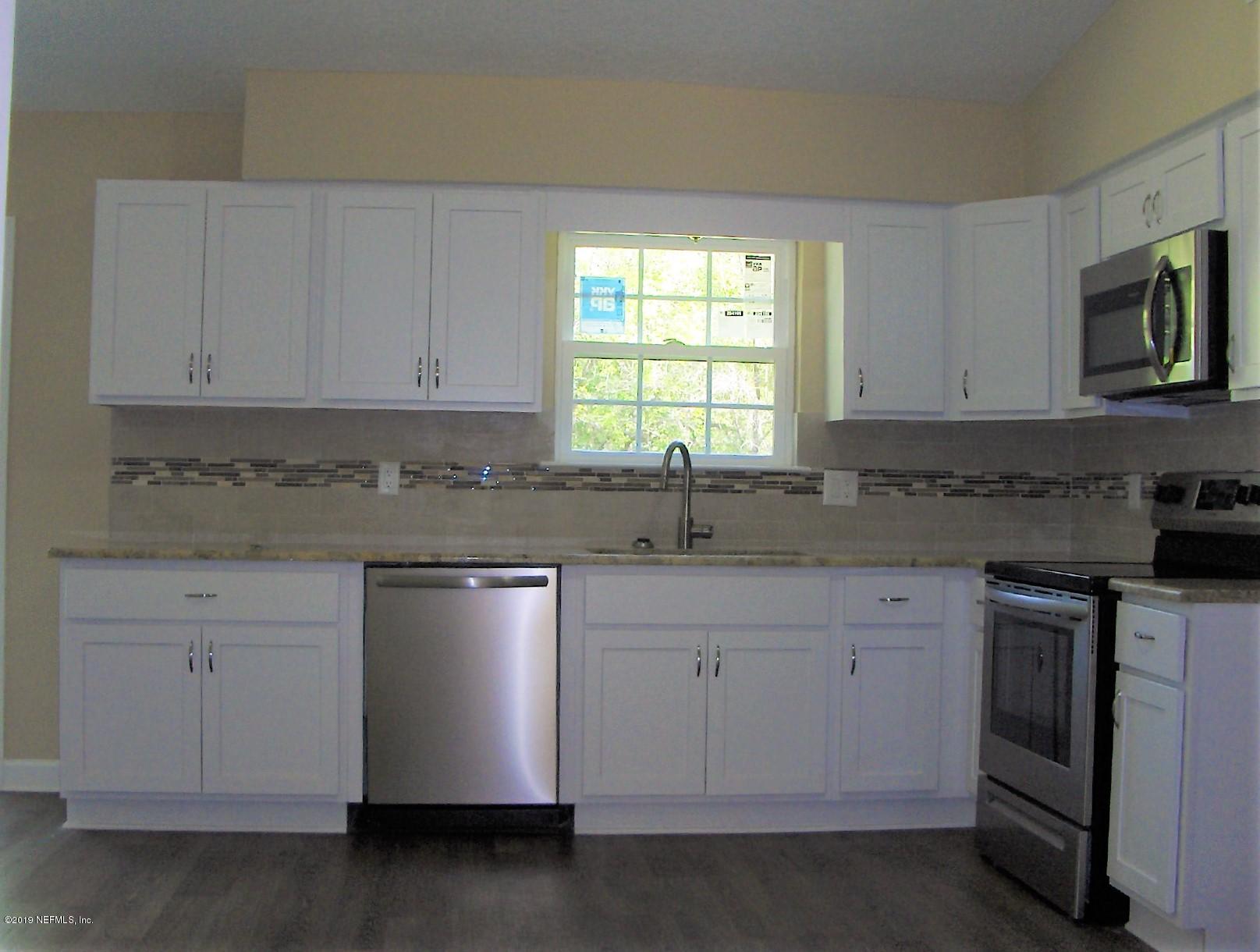 4122 Appaloosa Road Middleburg, FL 32068 - Photo 9 of 18 a kitchen with stainless steel appliances granite countertop a sink a stove and a microwave