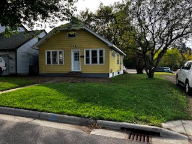 Bungalow-style home featuring a front yard and entry steps