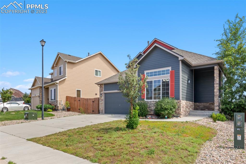 13099 Devil's Thumb Place Peyton, CO 80831 - Photo 3 of 25 a front view of house with yard and trees around