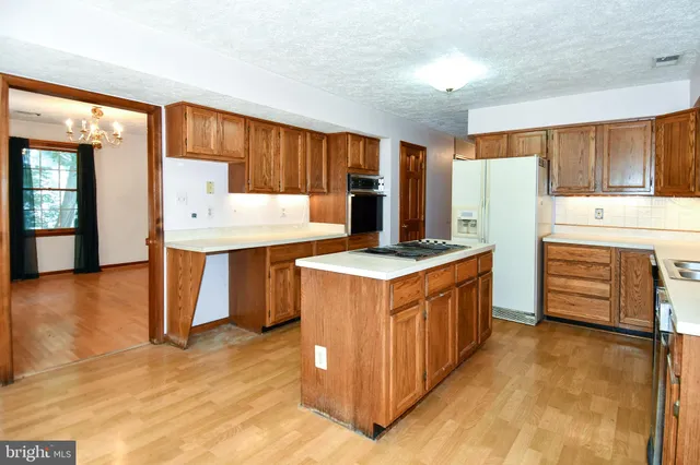 a kitchen with stainless steel appliances a stove a refrigerator and wooden cabinets