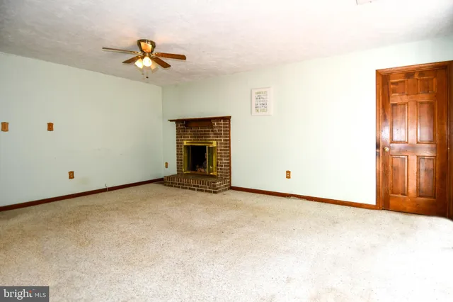 a view of a livingroom with a ceiling fan and window