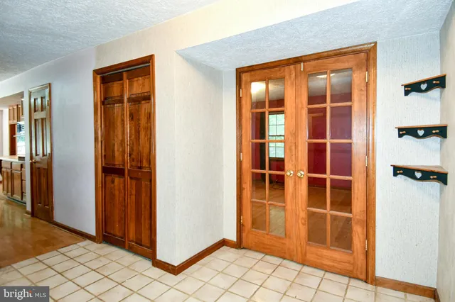 a view of an empty room with wooden floor and a cabinet