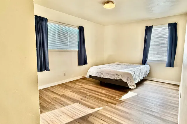 a bedroom with a bed and wooden floor