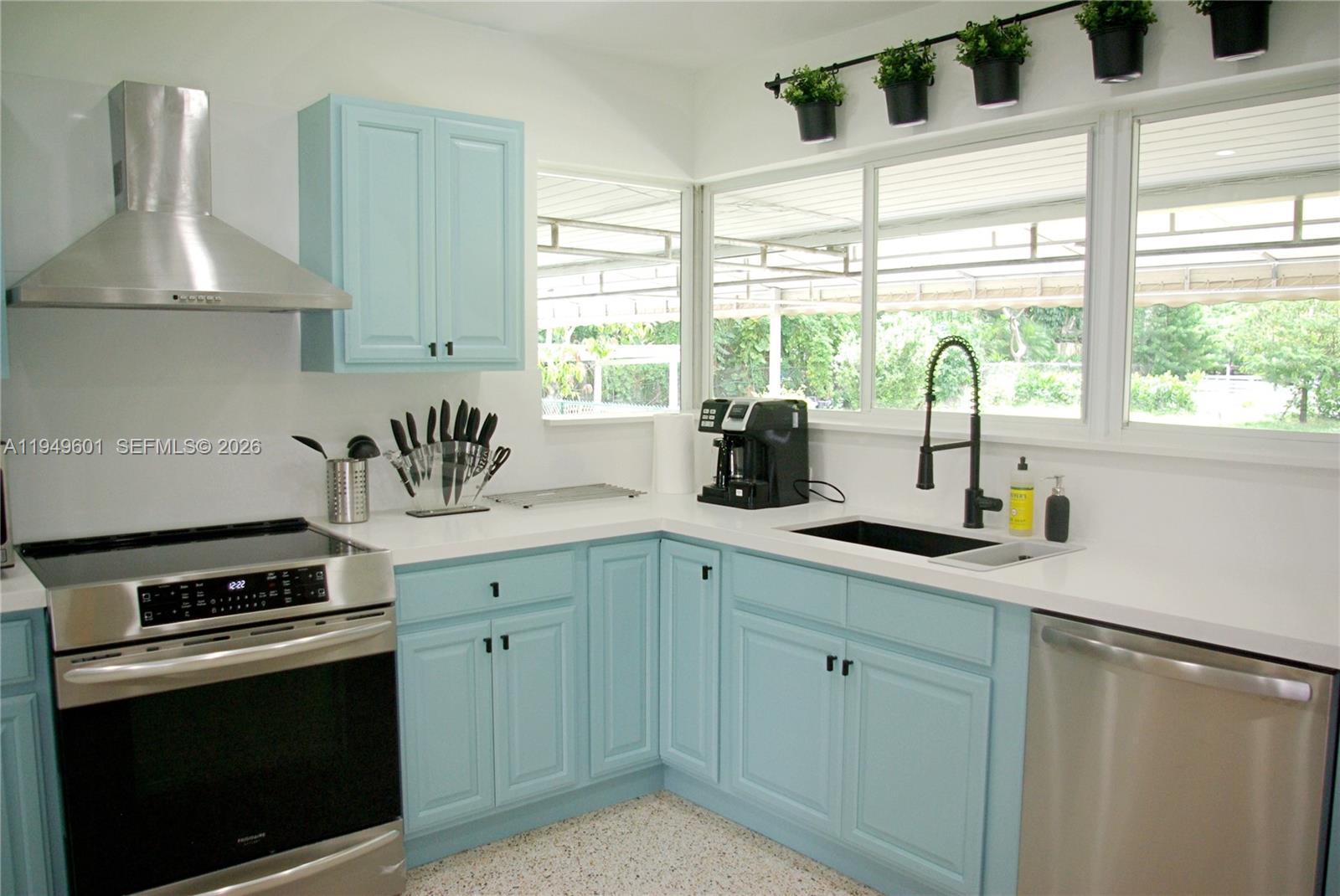 29450 Southwest 180th Avenue Homestead, FL 33030 - Photo 8 of 32 a kitchen with stainless steel appliances white cabinets and a window