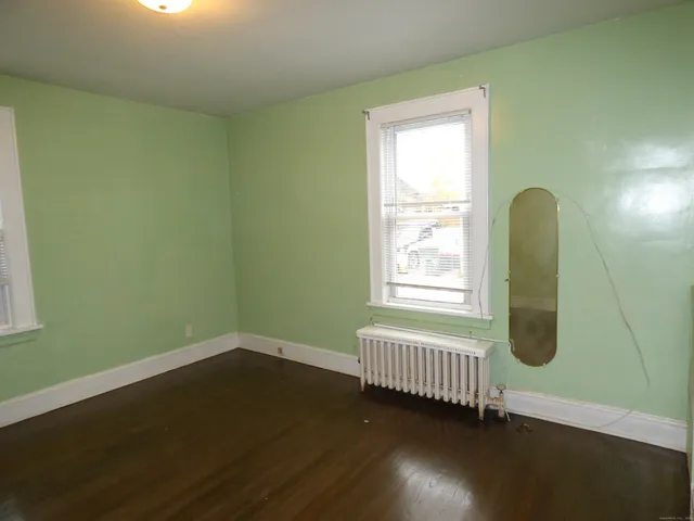 a view of a room with wooden floor and a window