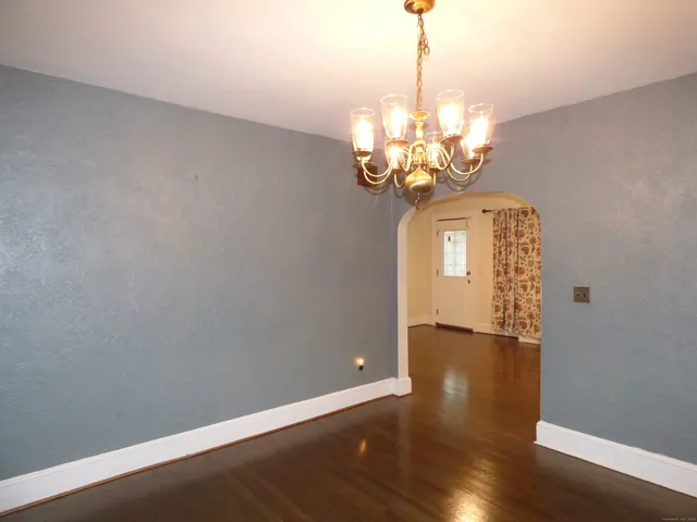 a view of a chandelier in big room with wooden floor