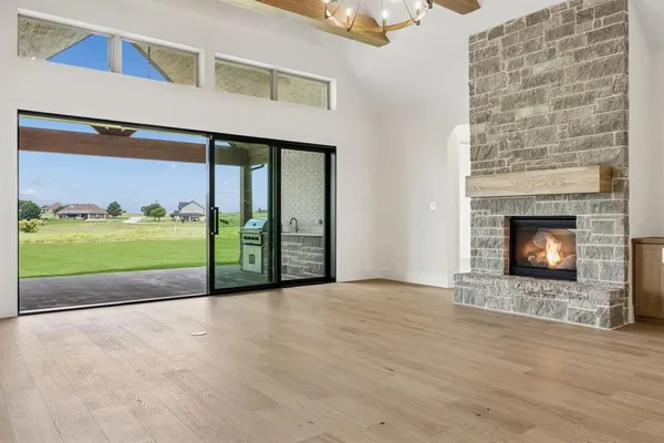a view of an empty room with a fireplace and a floor to ceiling window