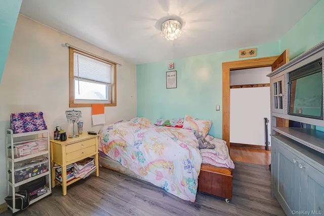 a bedroom with a bed and a tv on the dresser