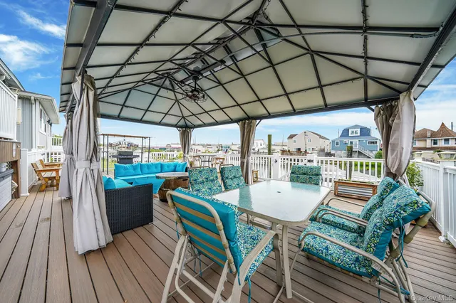 a view of a balcony with chairs and wooden floor