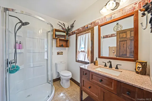 a bathroom with a granite countertop sink toilet and shower