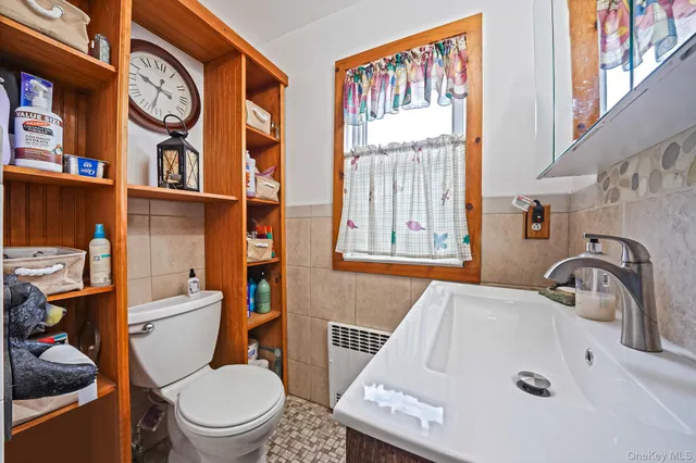 a bathroom with a sink a toilet and a window