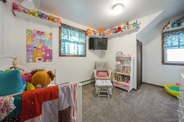 a living room with furniture and a baby crib