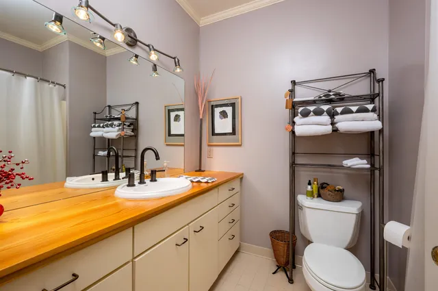 a bathroom with a granite countertop toilet sink and mirror