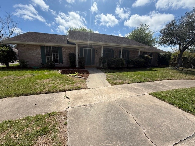 6410 Clearlake Circle Corpus Christi, TX 78413 - Photo 2 of 20 a front view of a house with a garden and trees