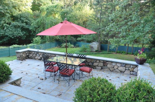 39 Windsor Road Wellesley, MA 02481 - Photo 12 of 23 a view of a chairs and table under an umbrella