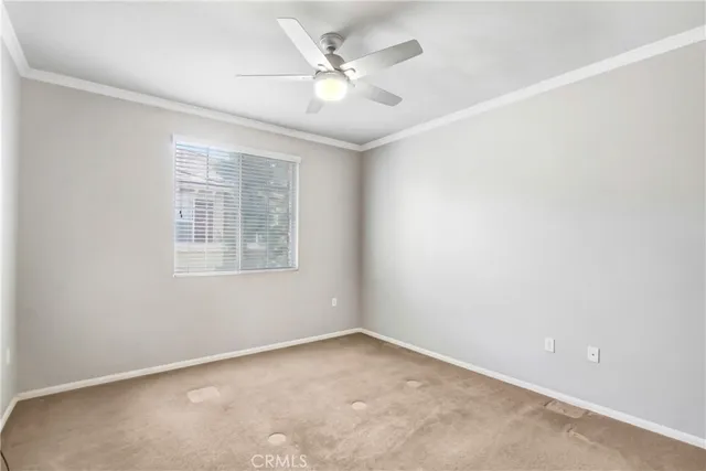 an empty room with windows and ceiling fan
