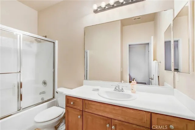 a bathroom with a granite countertop sink toilet a mirror and shower
