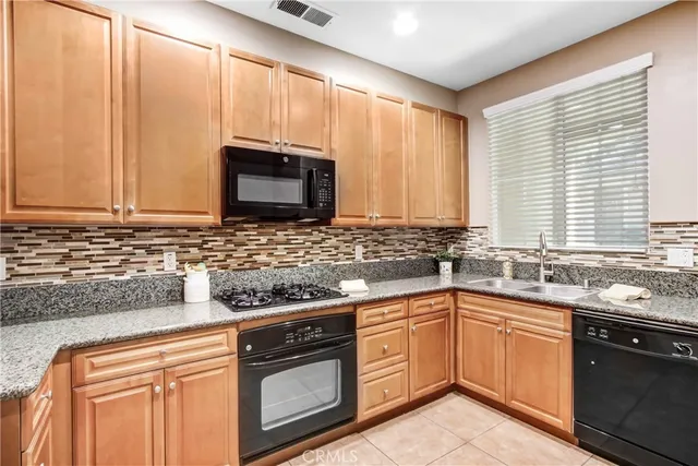 a kitchen with stainless steel appliances granite countertop a sink a stove a microwave and cabinets