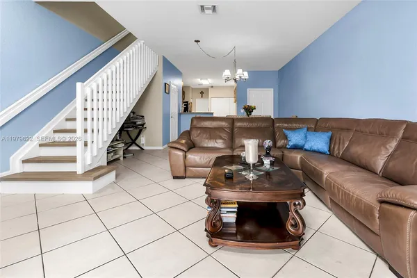 a living room with furniture and a chandelier