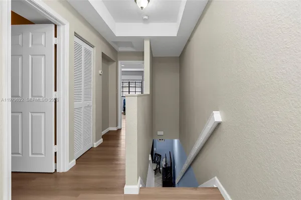 a view of a hallway with wooden floor and staircase