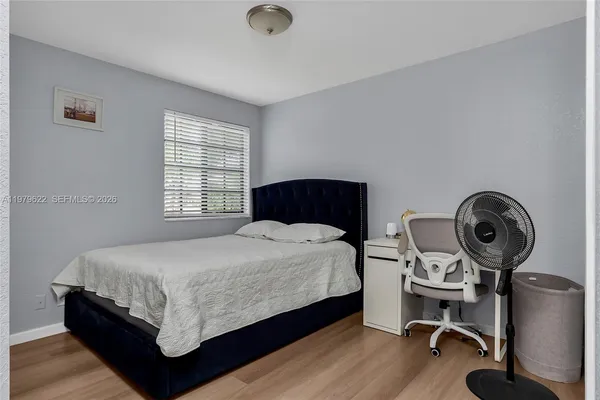 a bedroom with a bed and wooden floor