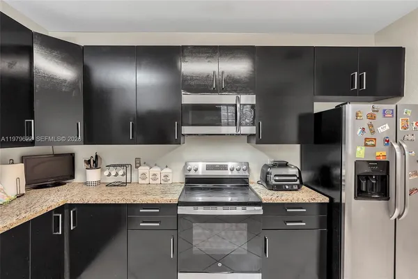 a kitchen with stainless steel appliances a sink stove and refrigerator