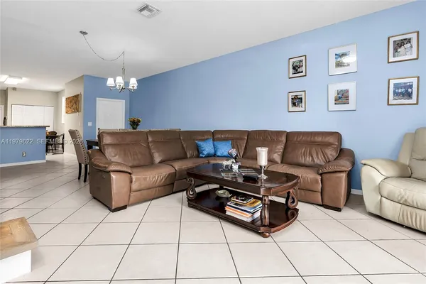 a living room with furniture and a chandelier