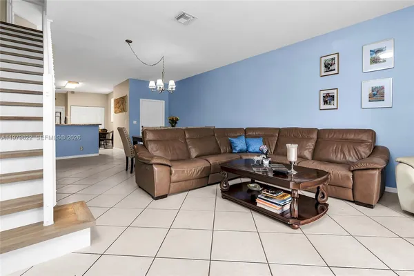 a living room with furniture and a chandelier
