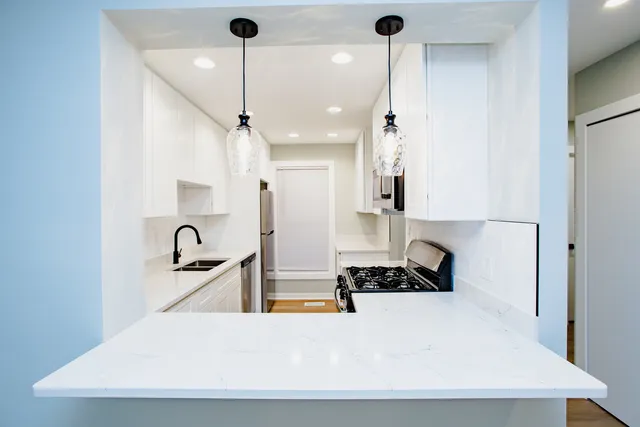 a kitchen with stainless steel appliances granite countertop a sink a stove and a refrigerator