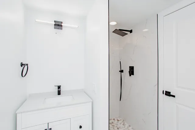 a bathroom with a shower sink and vanity