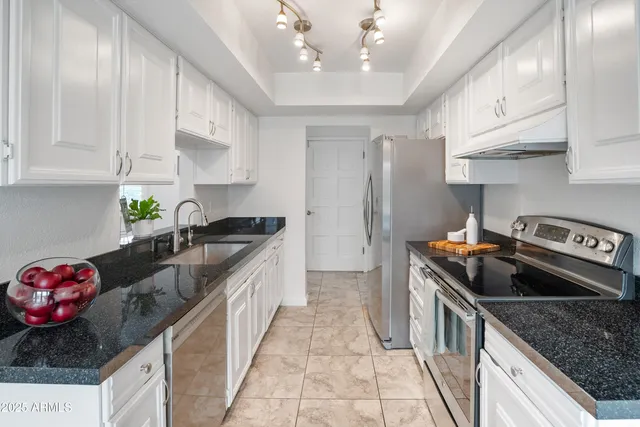 a kitchen with stainless steel appliances granite countertop a sink stove and cabinets