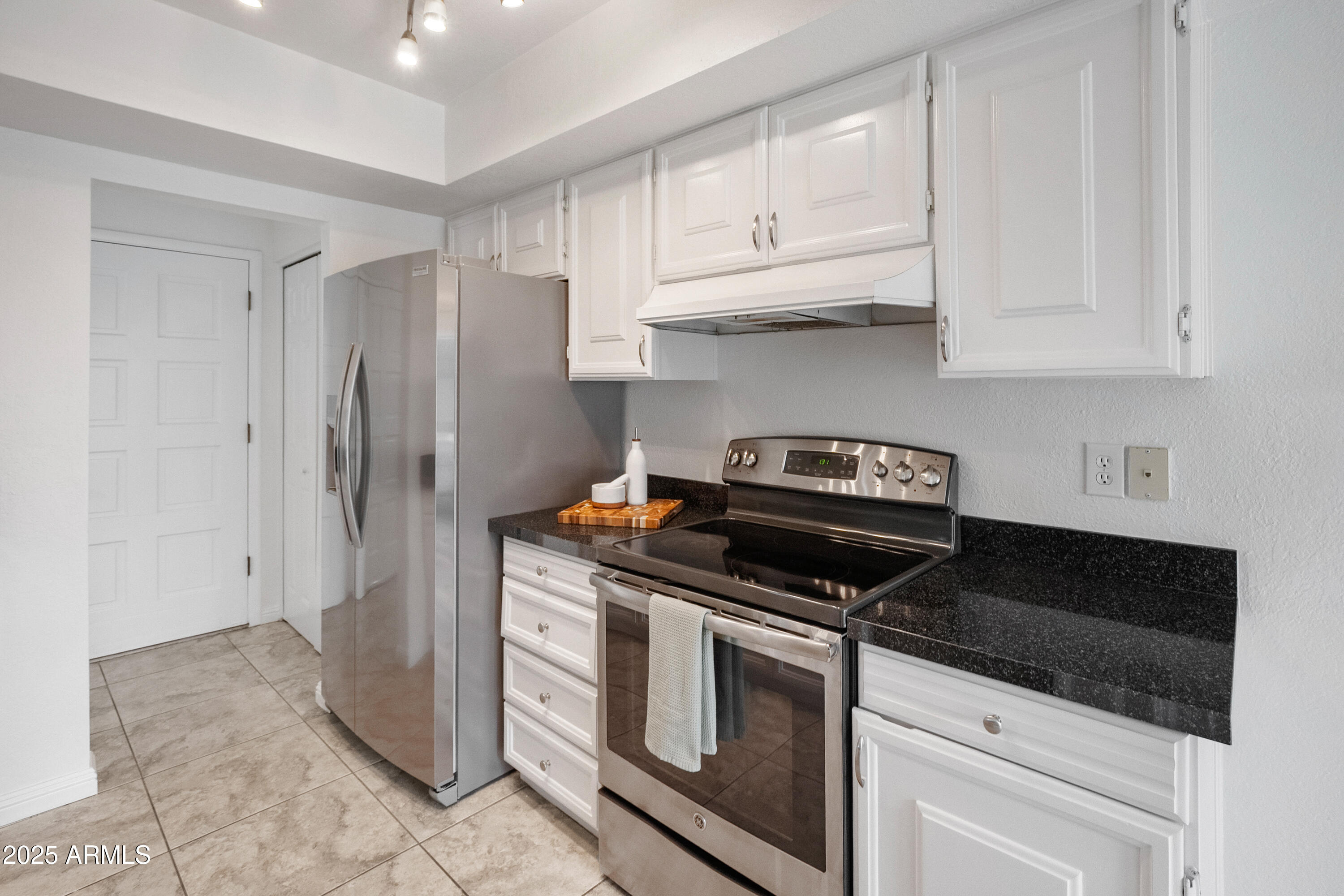 3928 North Granite Reef Road Scottsdale, AZ 85251 - Photo 12 of 30 a kitchen with granite countertop white cabinets and stainless steel appliances