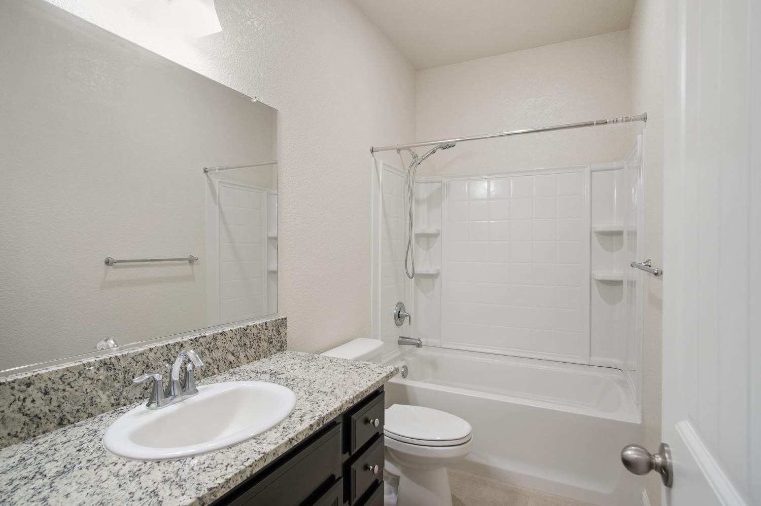 3790 Bonifacio Way Merced, CA 95340 - Photo 16 of 21 a bathroom with a granite countertop sink toilet and shower