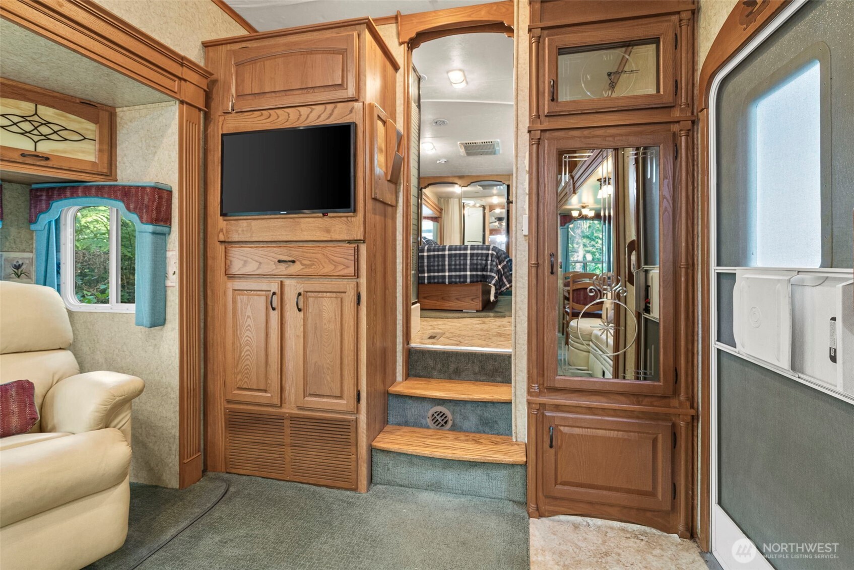560 North Beacon Point Loop North Lilliwaup, WA 98555 - Photo 11 of 40 a living room with furniture a flat screen tv and floor to ceiling window