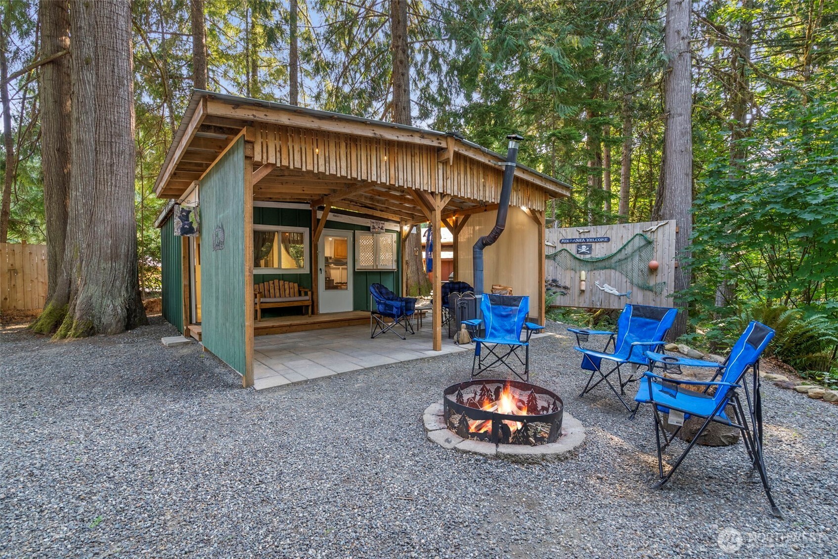 560 North Beacon Point Loop North Lilliwaup, WA 98555 - Photo 22 of 40 a backyard of a house with barbeque oven table and chairs