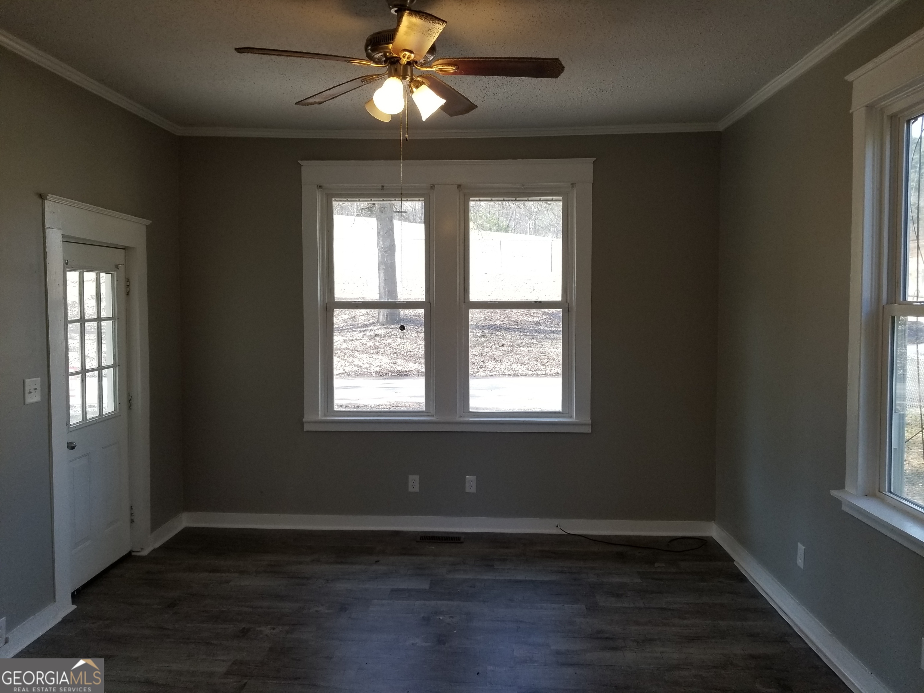 215 4th Street Rome, GA 30161 - Photo 4 of 12 an empty room with wooden floor a ceiling fan and windows