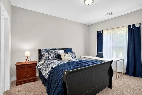 a bed sitting in a bedroom next to a window