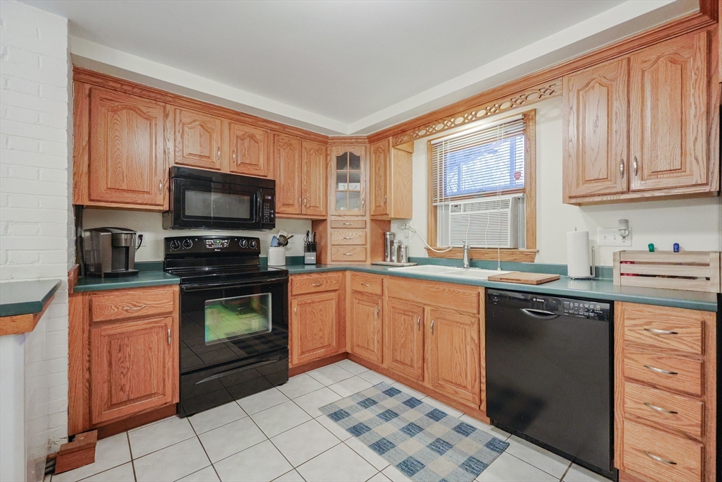 11 Edith Road Framingham, MA 01701 - Photo 6 of 37 a kitchen with stainless steel appliances granite countertop a stove a sink and a microwave