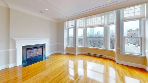 a view of an empty room with a fireplace and a window