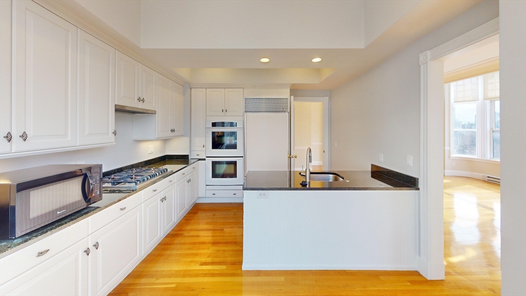22 Beacon Street, Unit 3 Boston, MA 02108 - Photo 9 of 28 a large kitchen with stainless steel appliances granite countertop a sink and a stove