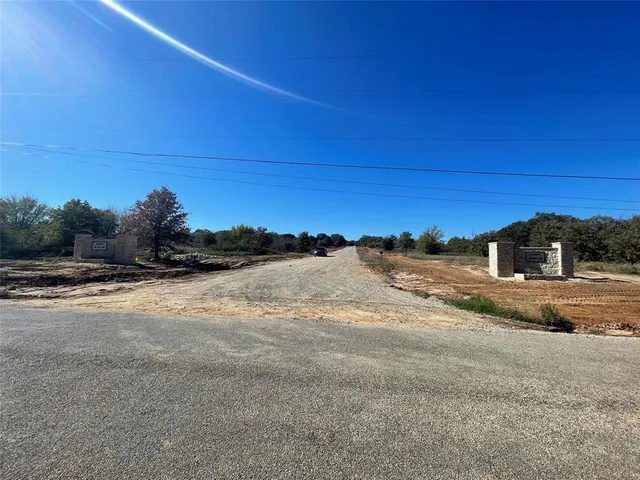 a view of dirt road with a building in the background
