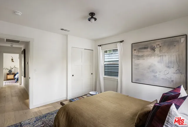 a bedroom with a bed and a painting on the wall