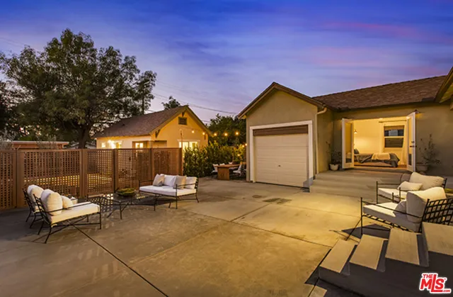a backyard of a house with table and chairs