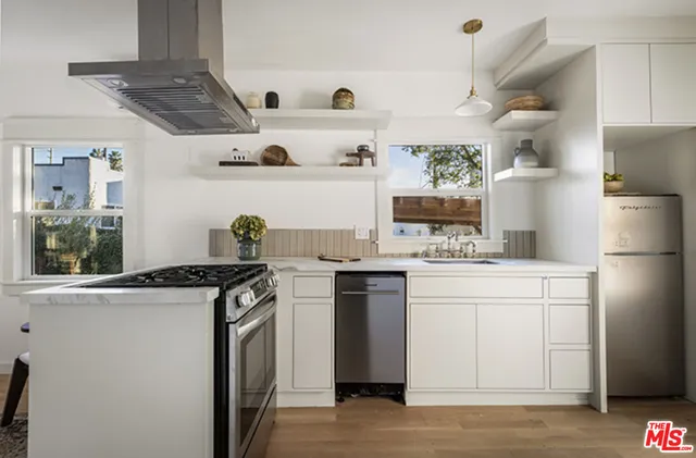 a kitchen with stainless steel appliances granite countertop a sink a stove and a refrigerator