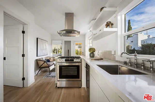 a kitchen with stainless steel appliances a stove a sink and a refrigerator