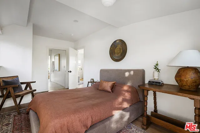 a bedroom with a bed and a lamp on dresser