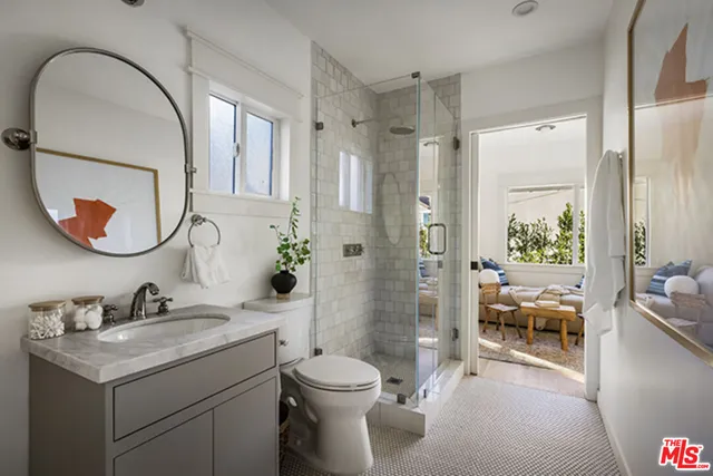 a bathroom with a granite countertop toilet a sink and a mirror