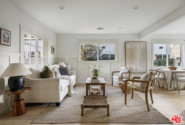 a living room with couches and a potted plant on a dresser